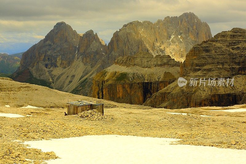 在田园诗般的Sas Pordoi和Passo Sella，朗科费尔顶峰山丘山脉正面在日落，戏剧性的全景和雄伟的白云石，意大利泰洛阿尔卑斯山脉